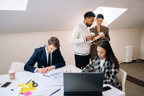 Free A diverse group of colleagues collaborating on a project in a modern office setting. Stock Photo