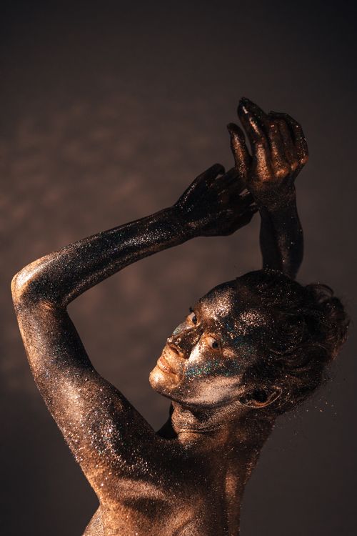 Free A woman with glitter makeup poses elegantly in a studio setting. Stock Photo