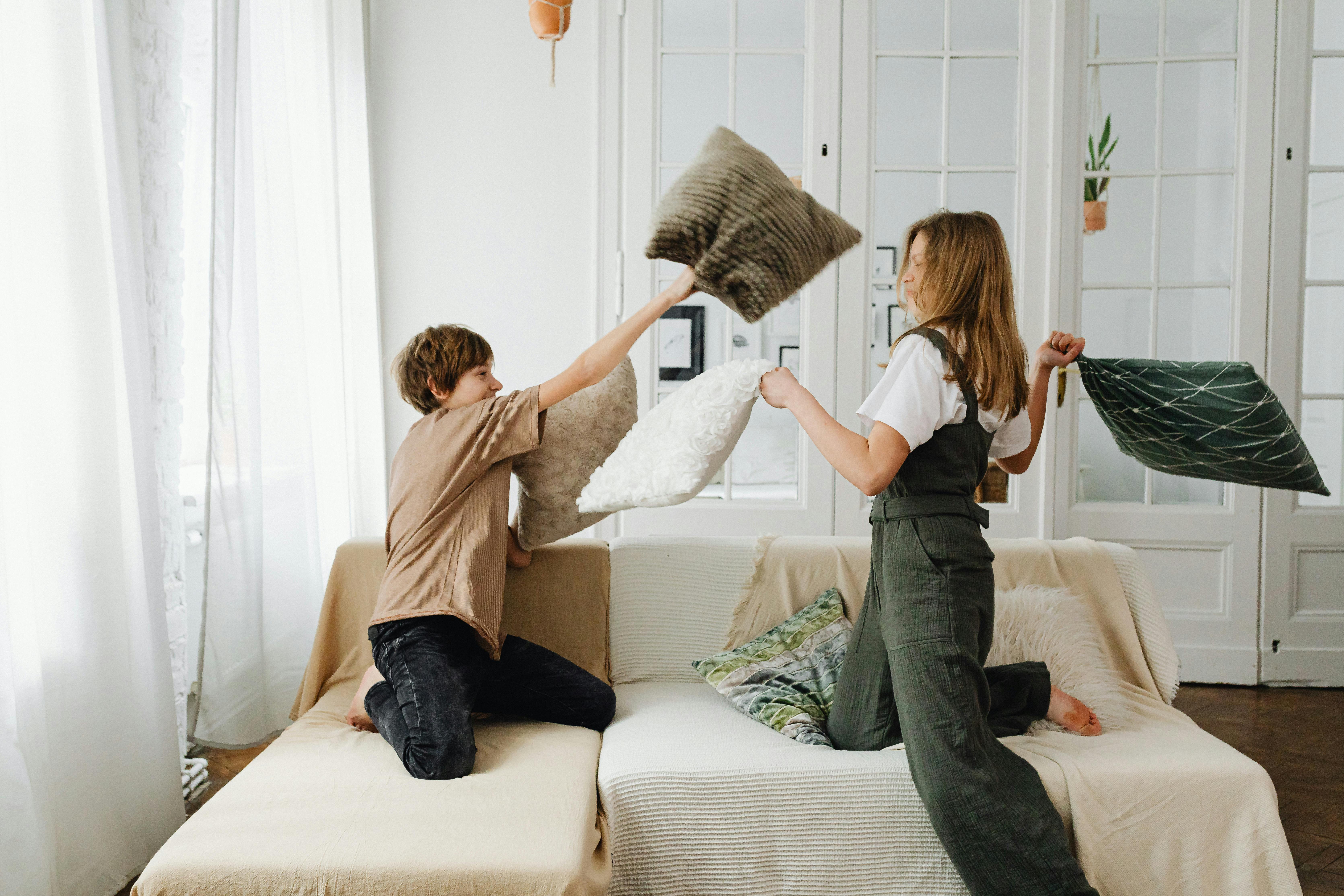 siblings playing pillow fight