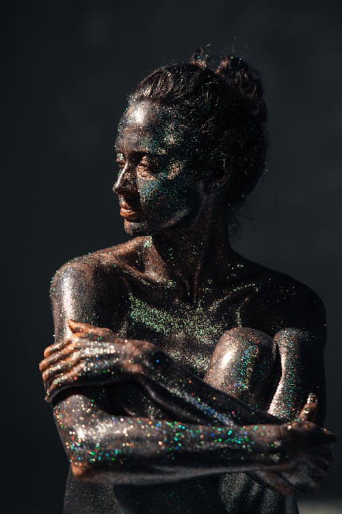A Woman with Glittery Make-Up Sitting while Looking Afar