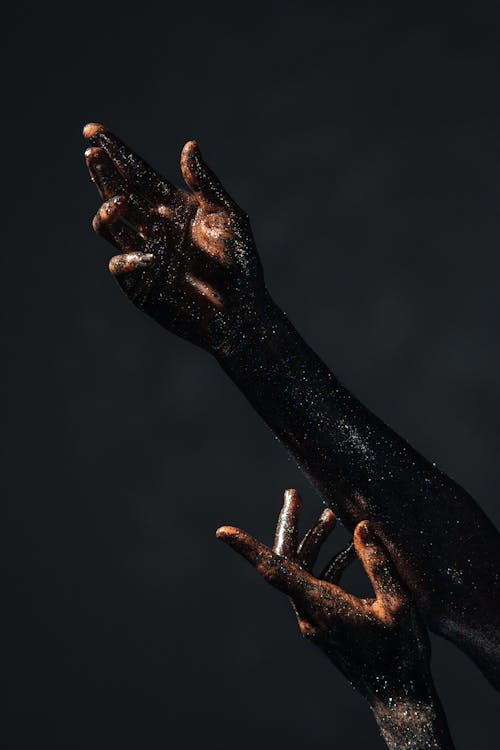 Hands and Arms Covered with Shiny Glitters in Close-up Photography