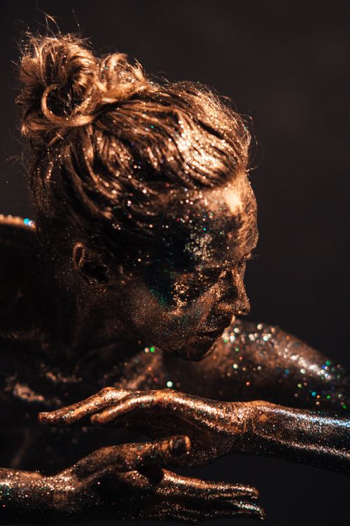 Free Captivating body art image featuring a model covered in glistening glitter in a studio setting. Stock Photo