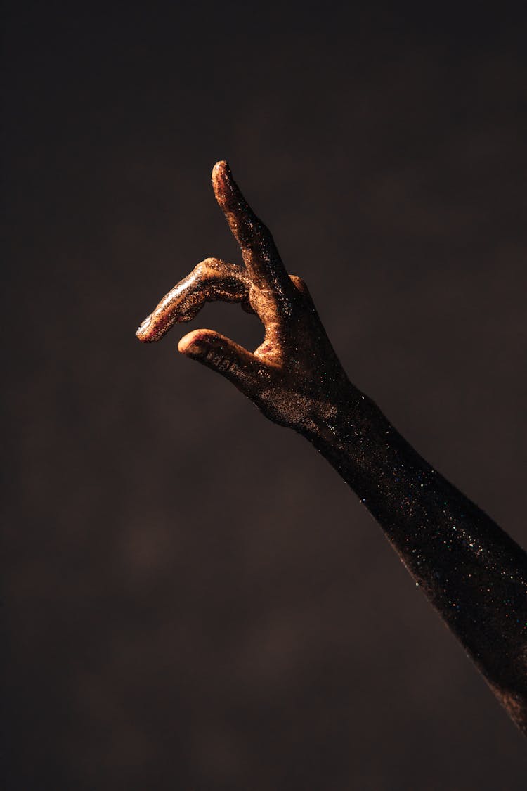 A Hand And Arm Covered With Glitters