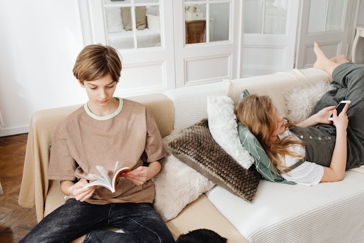 Siblings Resting On A Couch