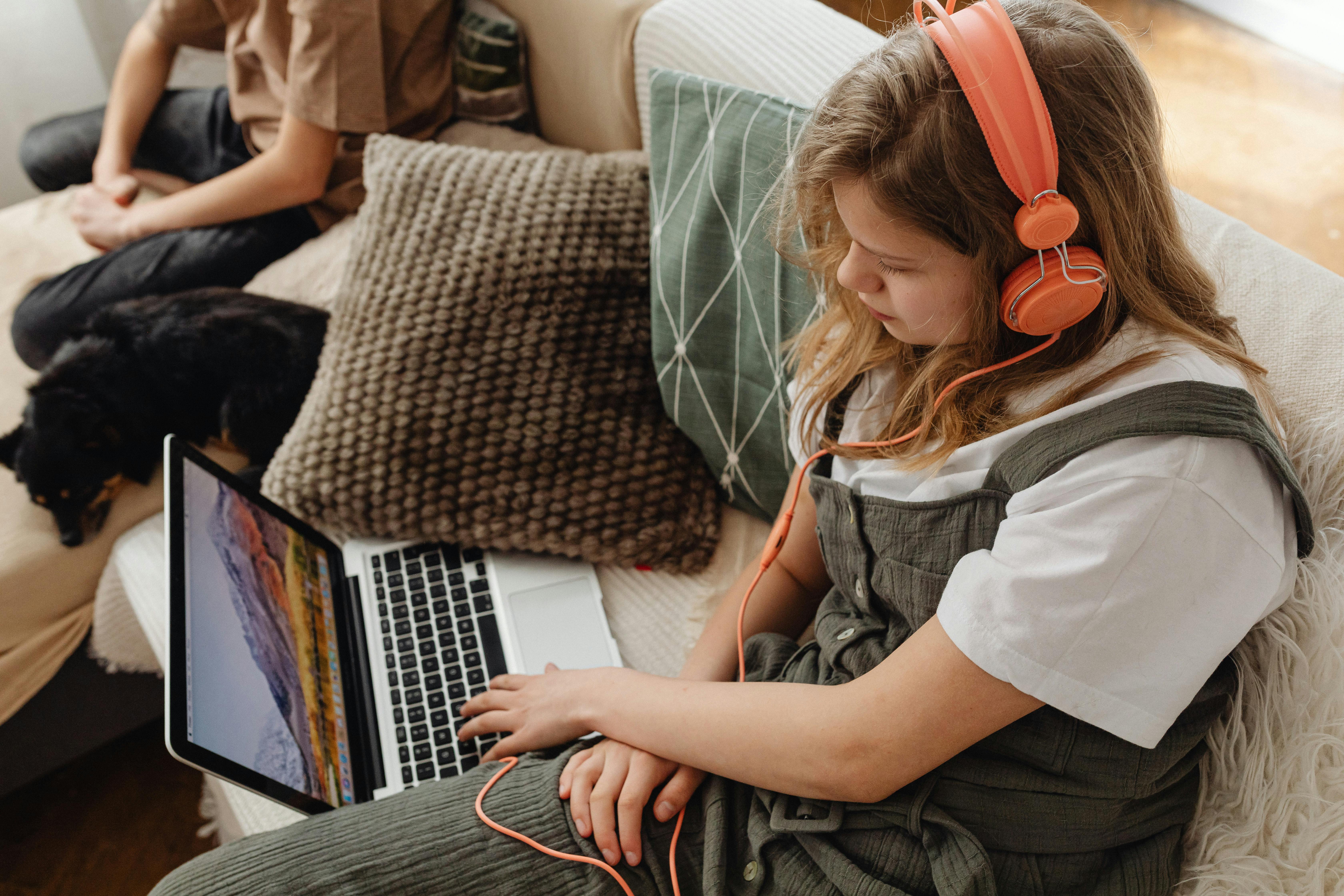 a woman wearing headphones using a laptop