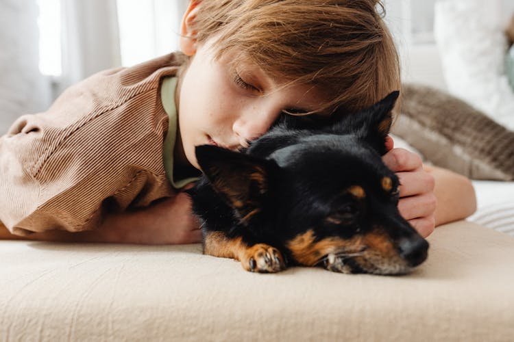 Close-Up Shot Of A Boy And Dog Sleeping 