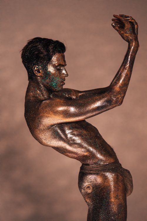 Free Stunning artistic photo of a male with glitter-covered body posing gracefully. Stock Photo