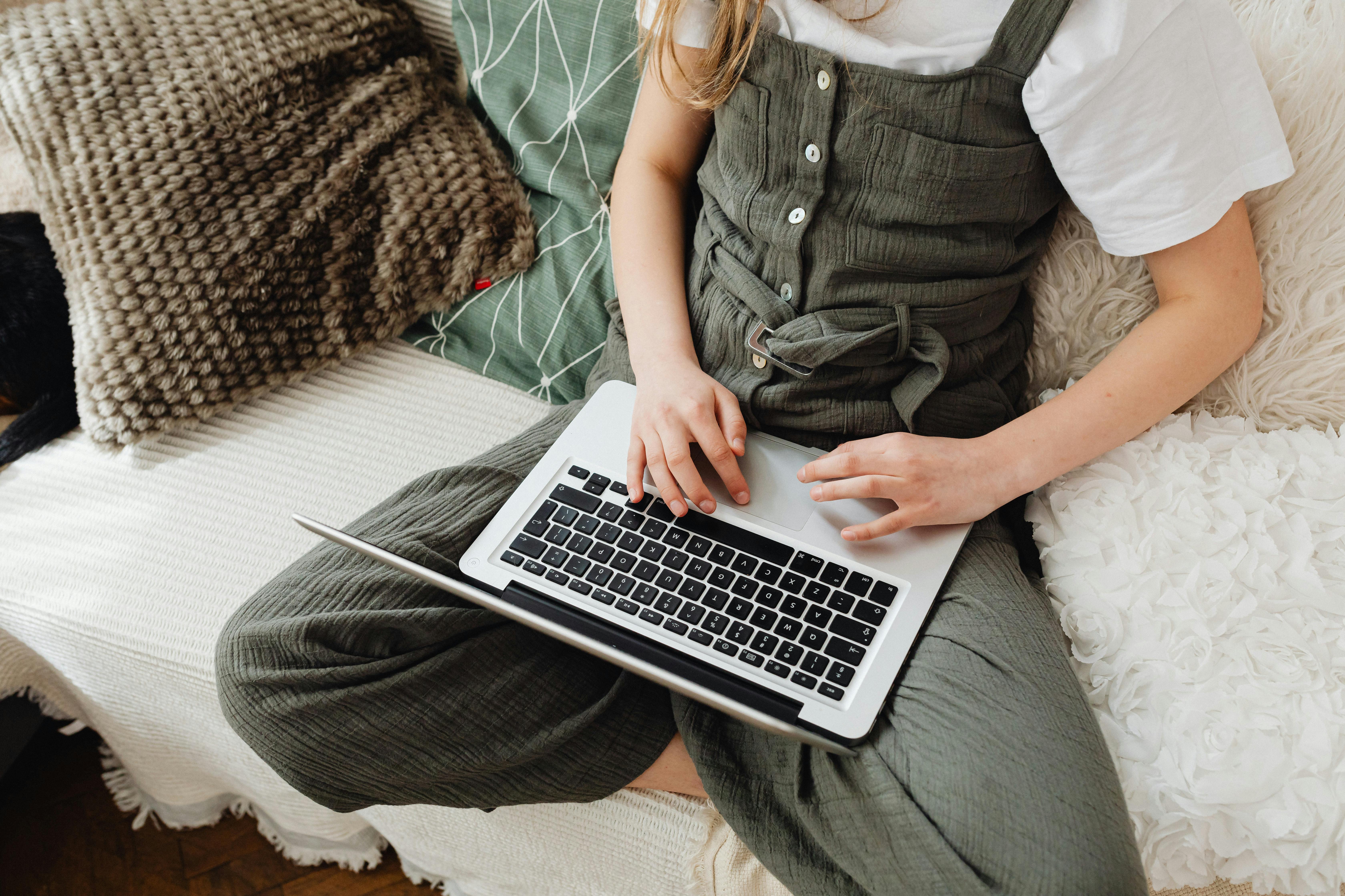 a teenager sitting and using a laptop