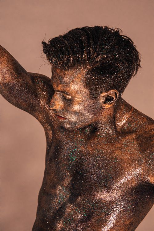 Free Striking artistic portrait of a man covered in shimmering glitter body paint. Stock Photo