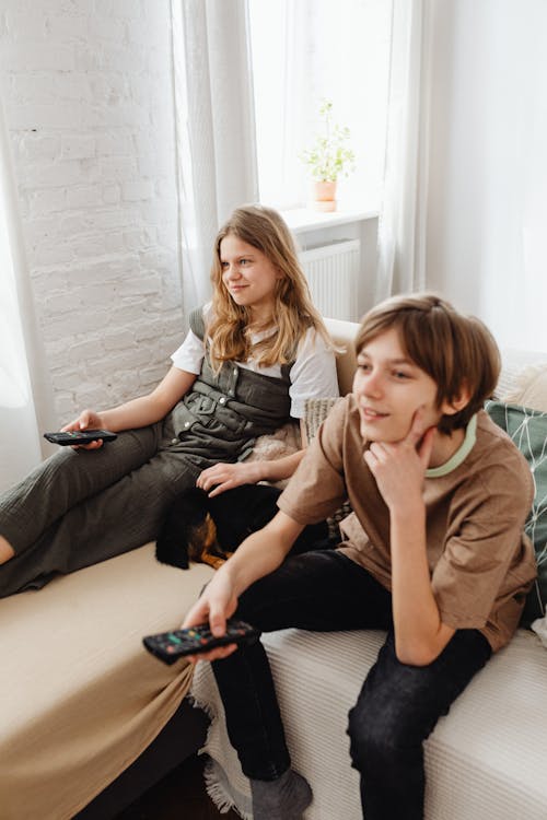 Siblings in the Living Room Watching Television Together  