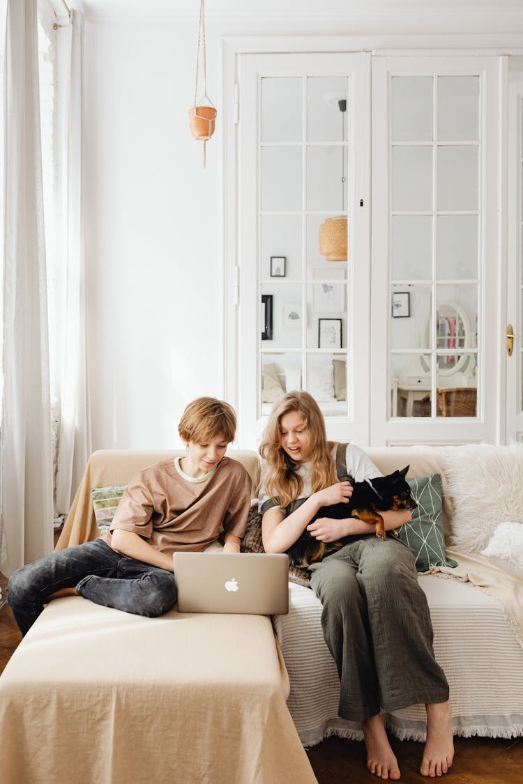 Girl Carrying Her Dog While Watching On The Laptop 