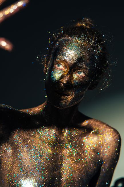 A captivating portrait of a woman adorned in shimmering glitter body paint.