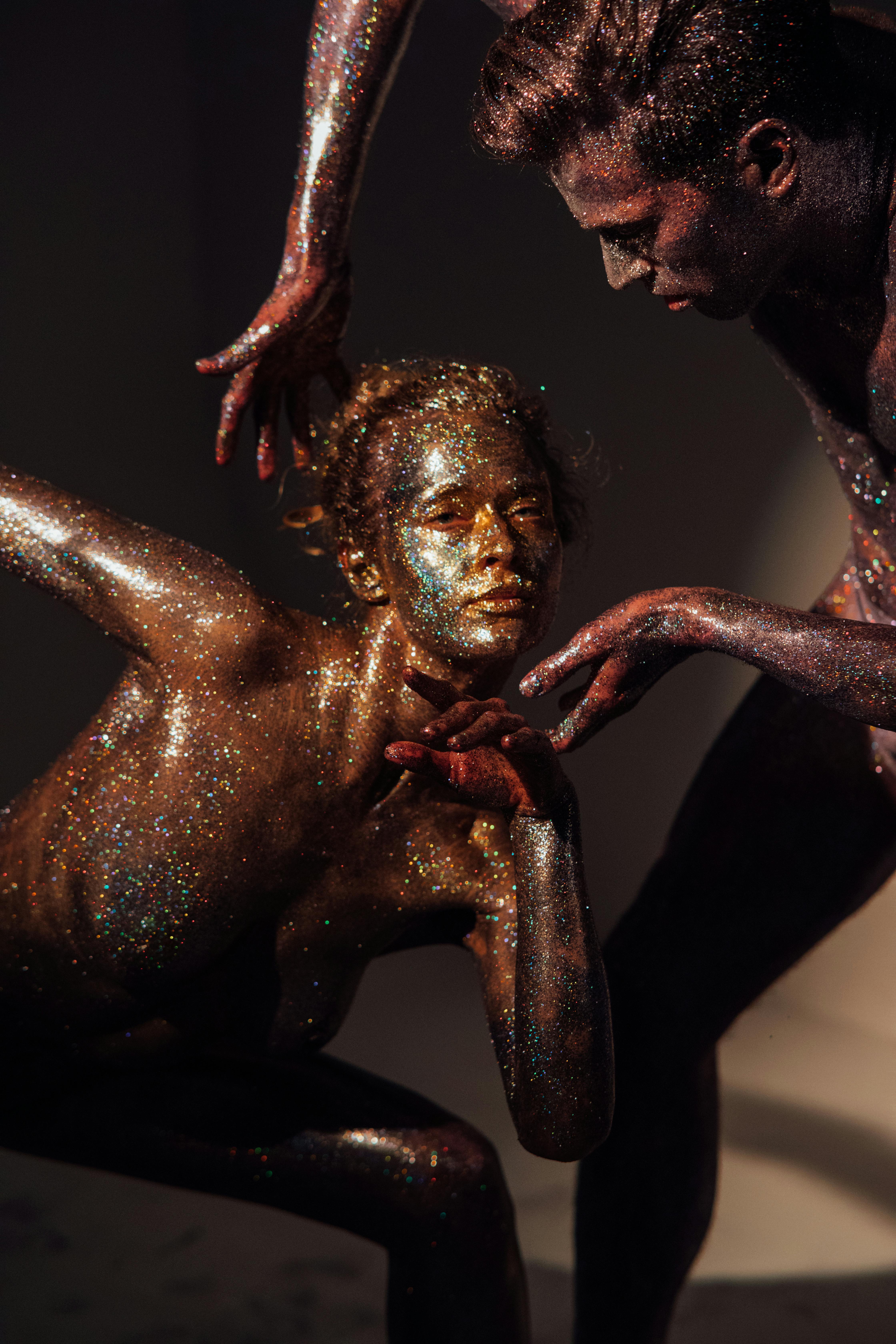 a man and a woman covered with shimmering body paint