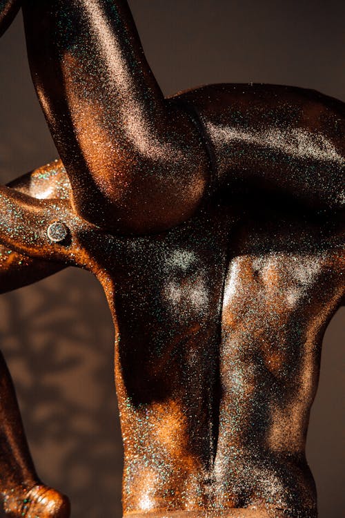 Models Covered with Glitters Posing as Bronze Statues