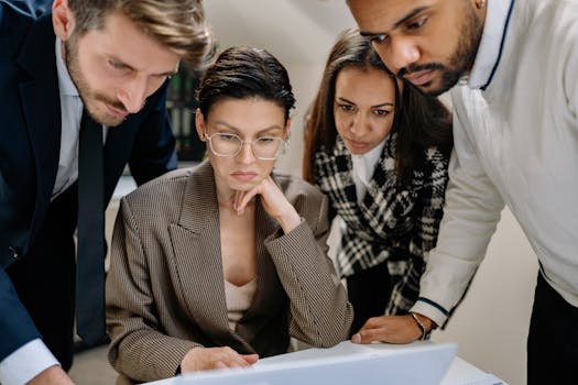 Diverse business team analyzing data collaboratively in a modern office setting.