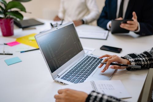 Free Professionals analyze financial data on laptop during office meeting. Stock Photo