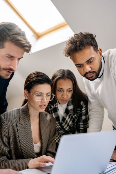 A small team reviewing work together on a laptop. Photo by Yan Krukau on Pexels