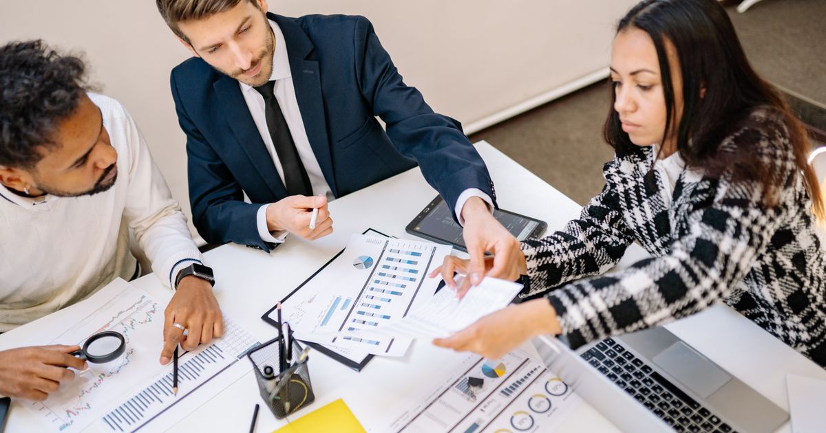 Business professionals engaging in a collaborative meeting with charts and documents.