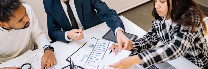 Business professionals engaging in a collaborative meeting with charts and documents.