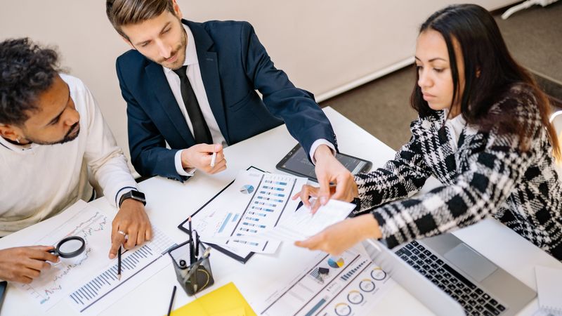 Business professionals engaging in a collaborative meeting with charts and documents.