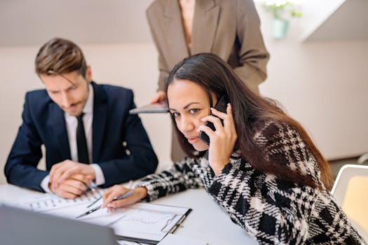 Professional meeting with focused teamwork and phone communication.