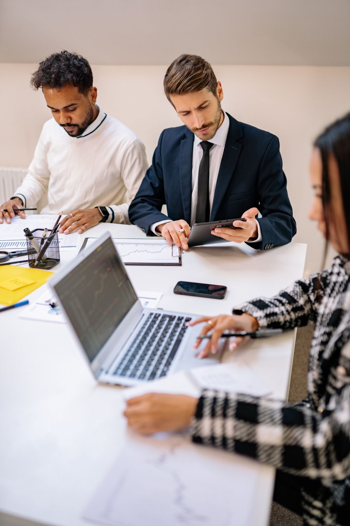 Three professionals working together in a modern office.