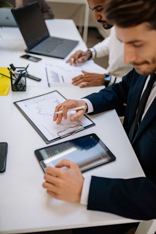 Free Business professionals working with tablet and documents in a modern office. Stock Photo