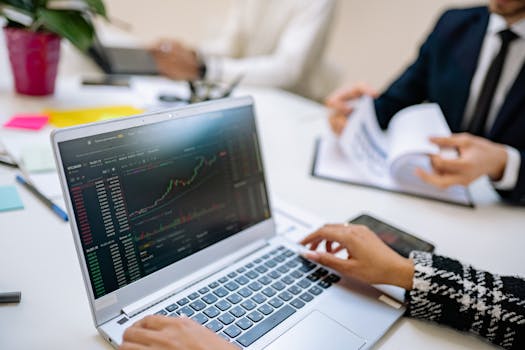 Business team analyzes cryptocurrency market trends using a laptop with graphs and data.