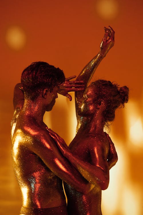 Man and Woman Dancing with Glitters on Body 