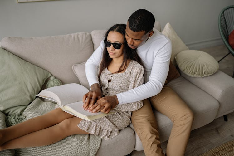 A Couple Sitting On A Sofa