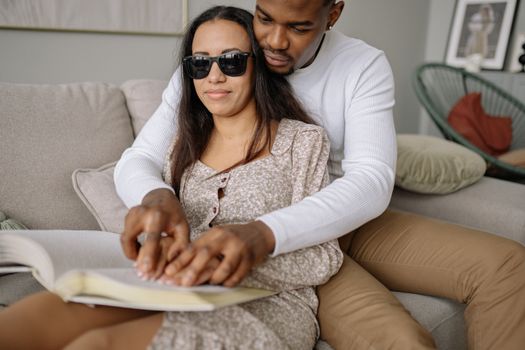Woman in White Cardigan Wearing Black Sunglasses Sitting on Couch