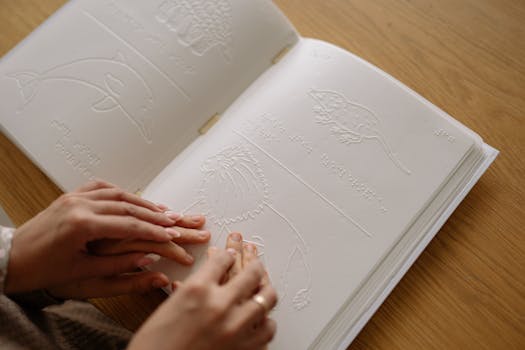 Hands exploring a braille book with tactile animal illustrations for educational purposes.