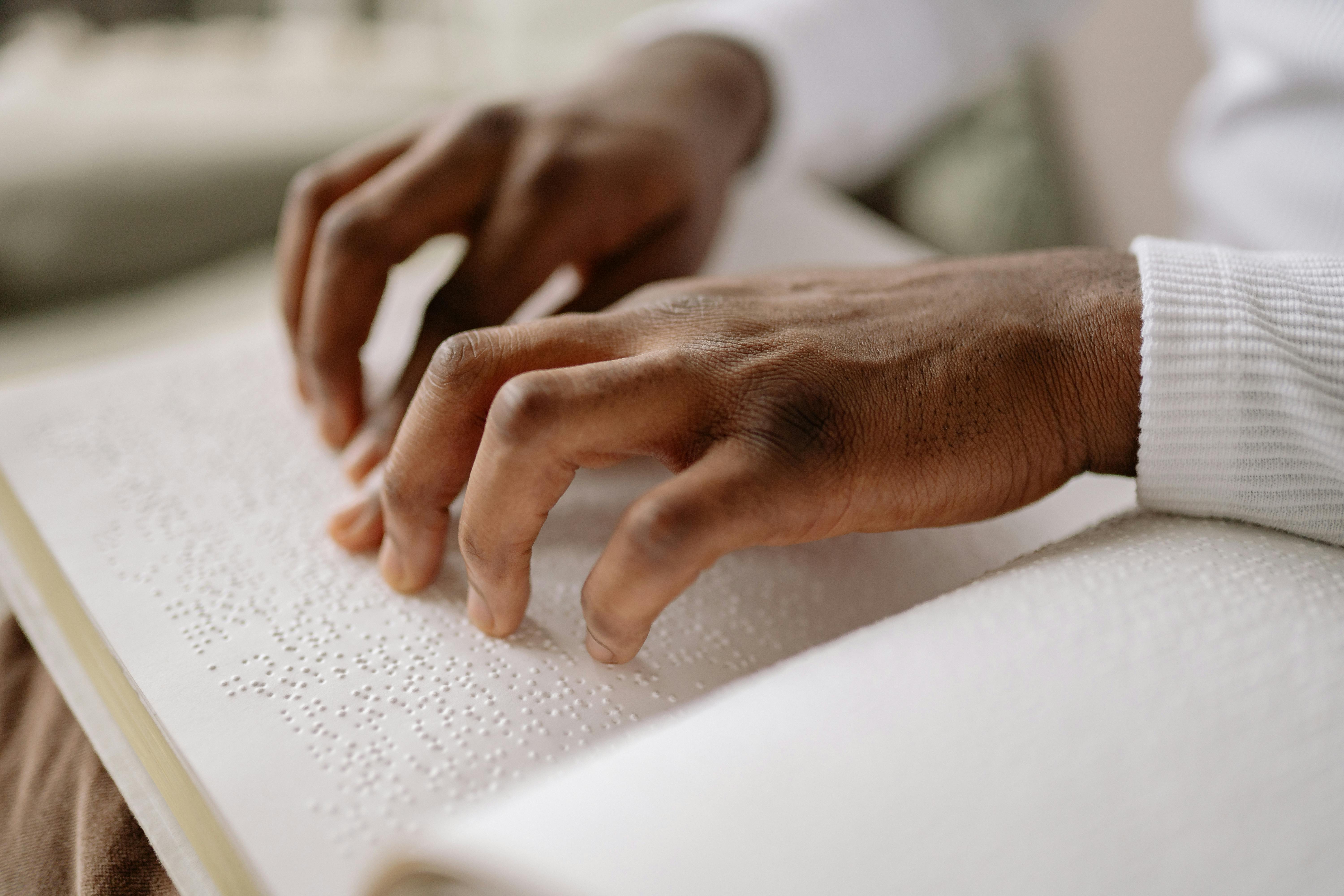 close up of a person reading a braille book