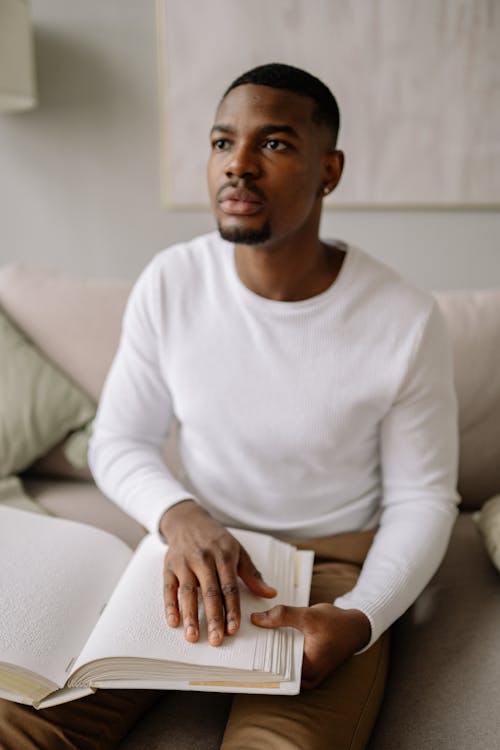 Free Man in White Long Sleeve Shirt Sitting on White Couch Stock Photo