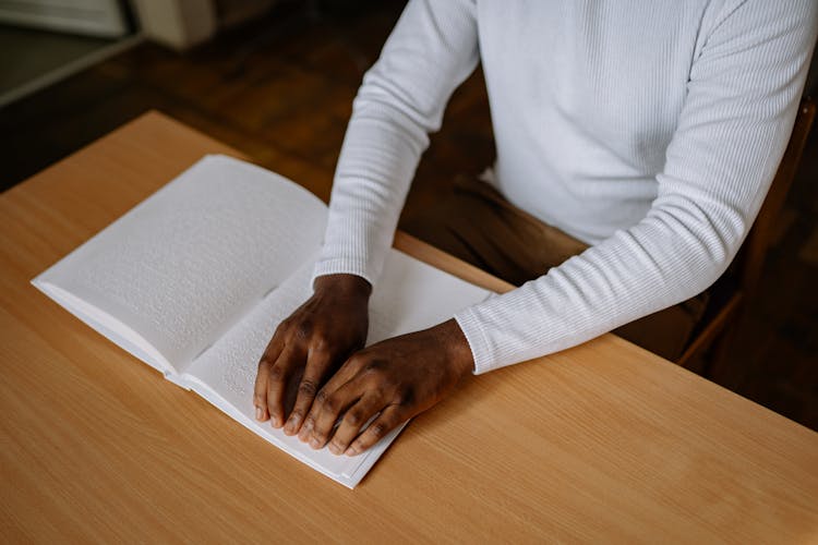 A Person Touching A Braille Book