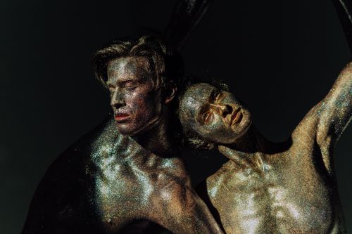 Free Two figures artistically covered in glitter, embracing an expressive pose. Stock Photo