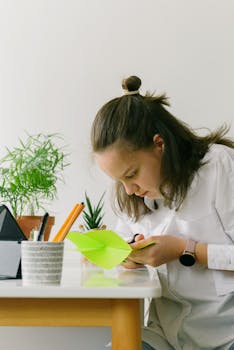 A Teenager Making a Papercraft Project at Home