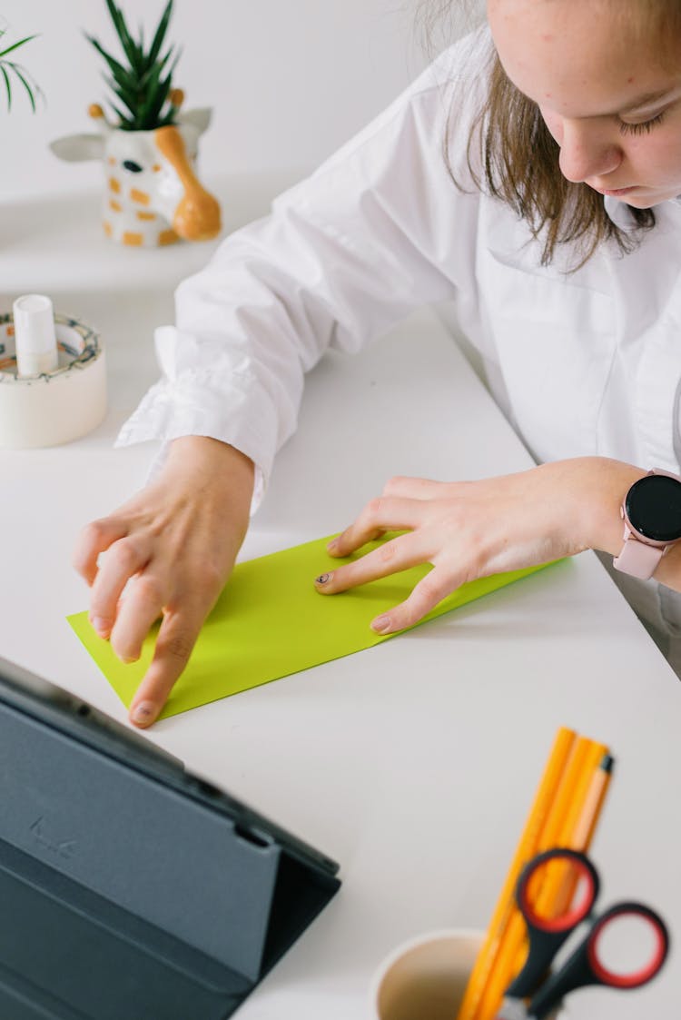 A Woman Folding A Piece Of Paper