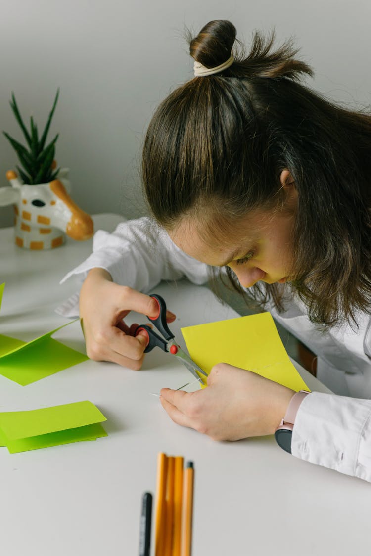 A Woman Cutting A Paper