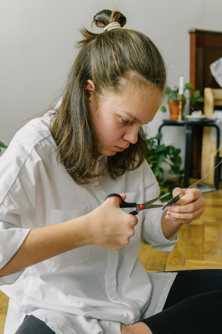 A Woman Cutting A Paper