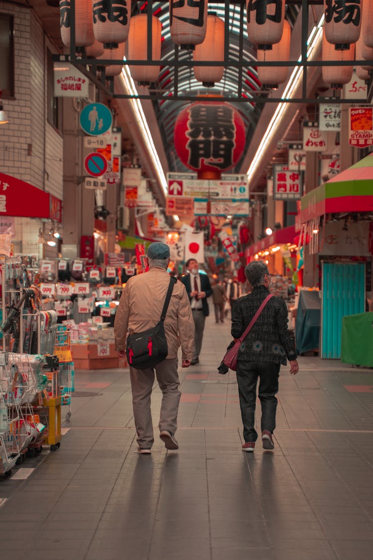 Woman And Man Walking On Bazaar