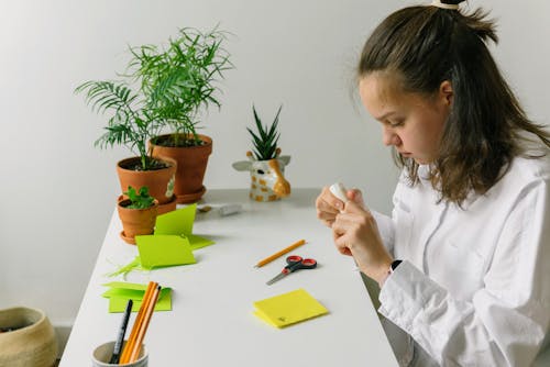 A Young Woman in White Dress Shirt Holding a Glue