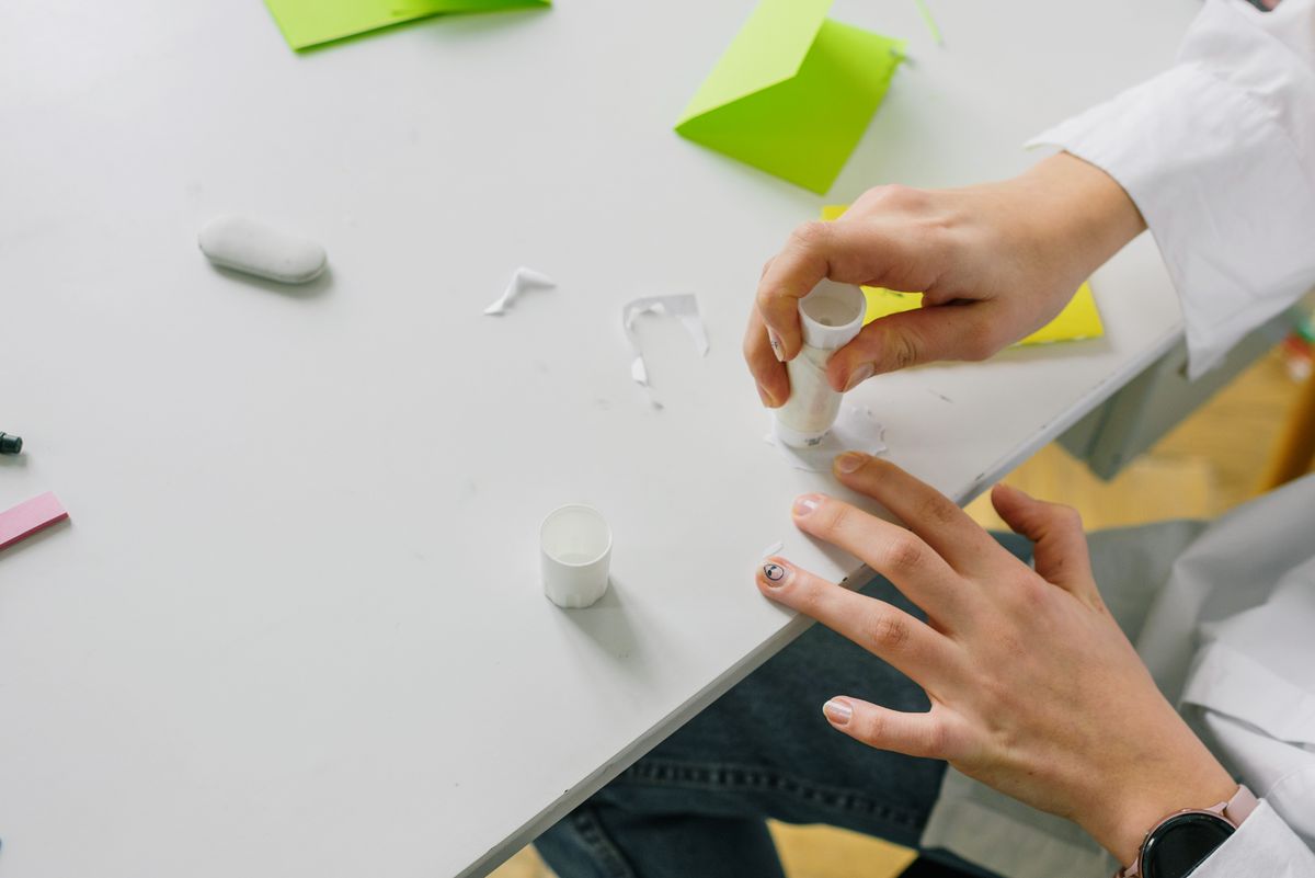 Một người thao tác keo trên mảnh giấy thủ công