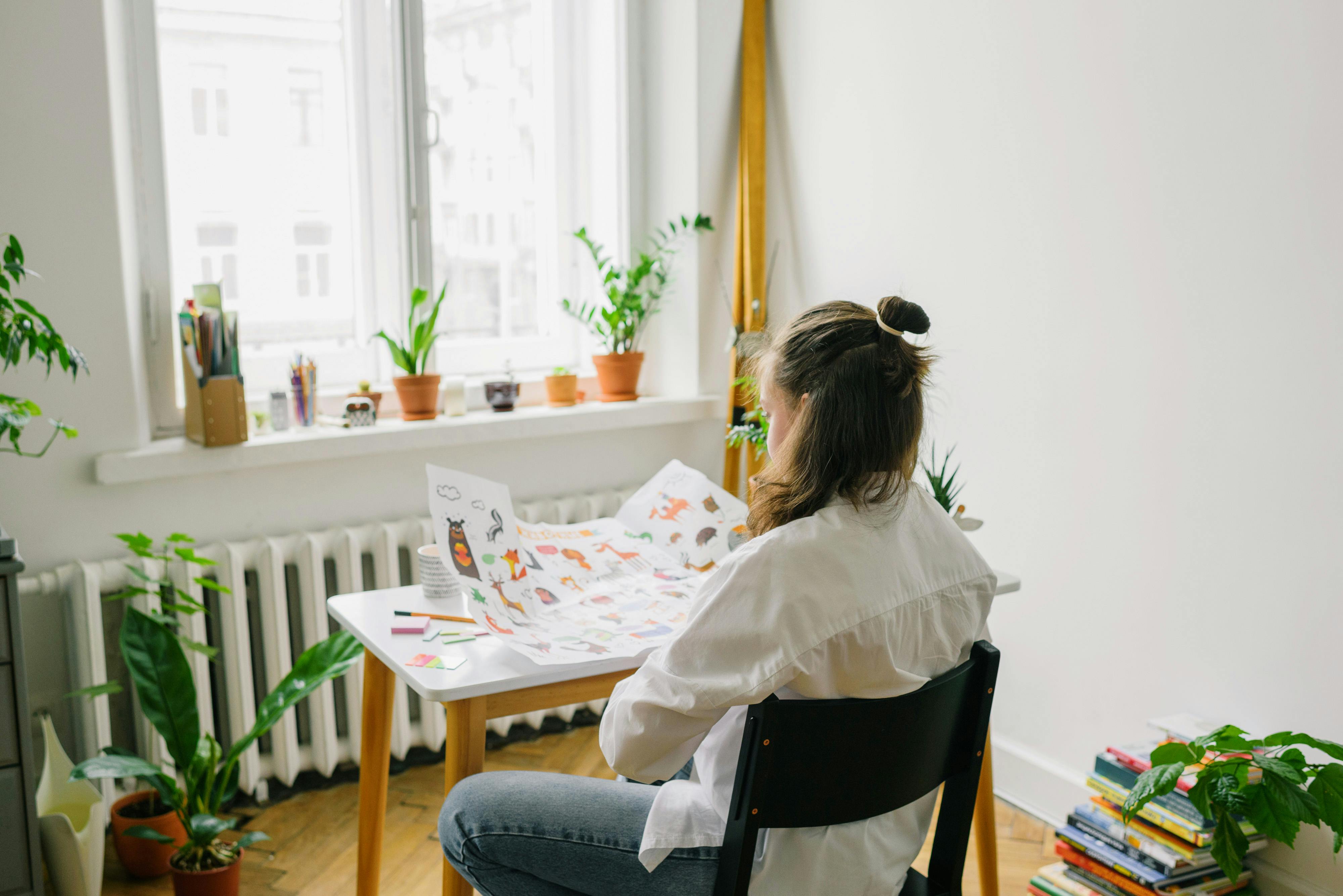 Woman in White Long Sleeve Shirt Sitting on Chair