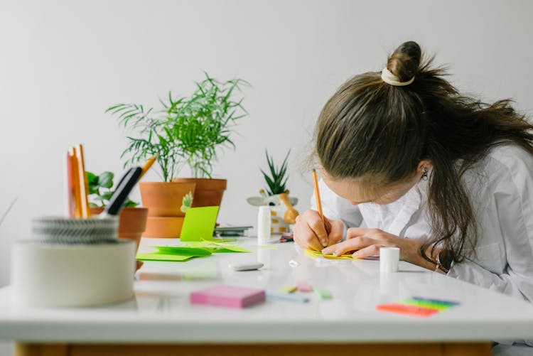 Woman In White Shirt Writing On White Paper