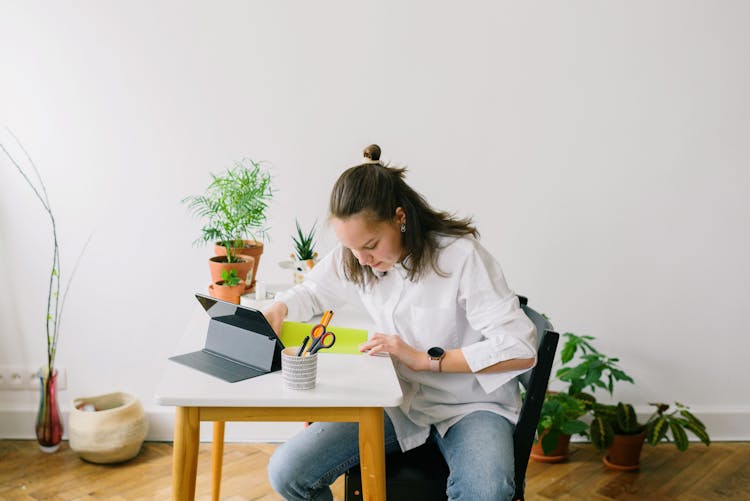 Woman Sitting On Black Chair Holding Yellow Paper