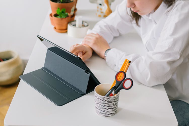 A Person Using Digital Table On The Table