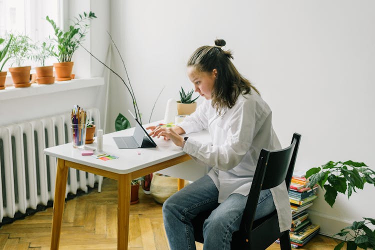 Teenager Using Ipad On A White Table 