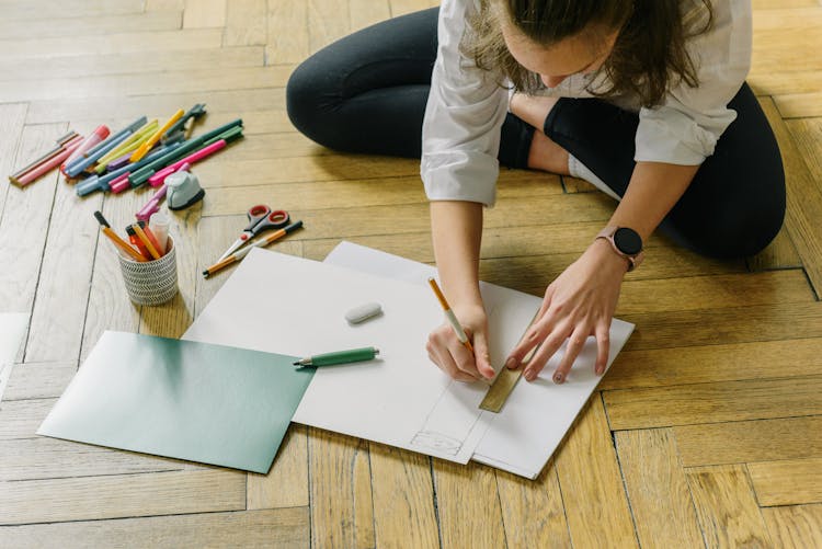 Woman Sitting On The Floor Tracing On White Cardboard