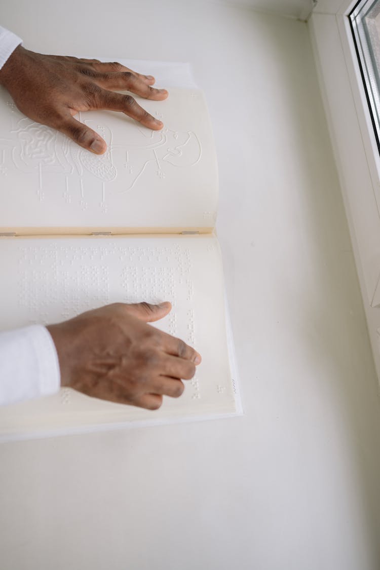 A Person Reading A Braille Book